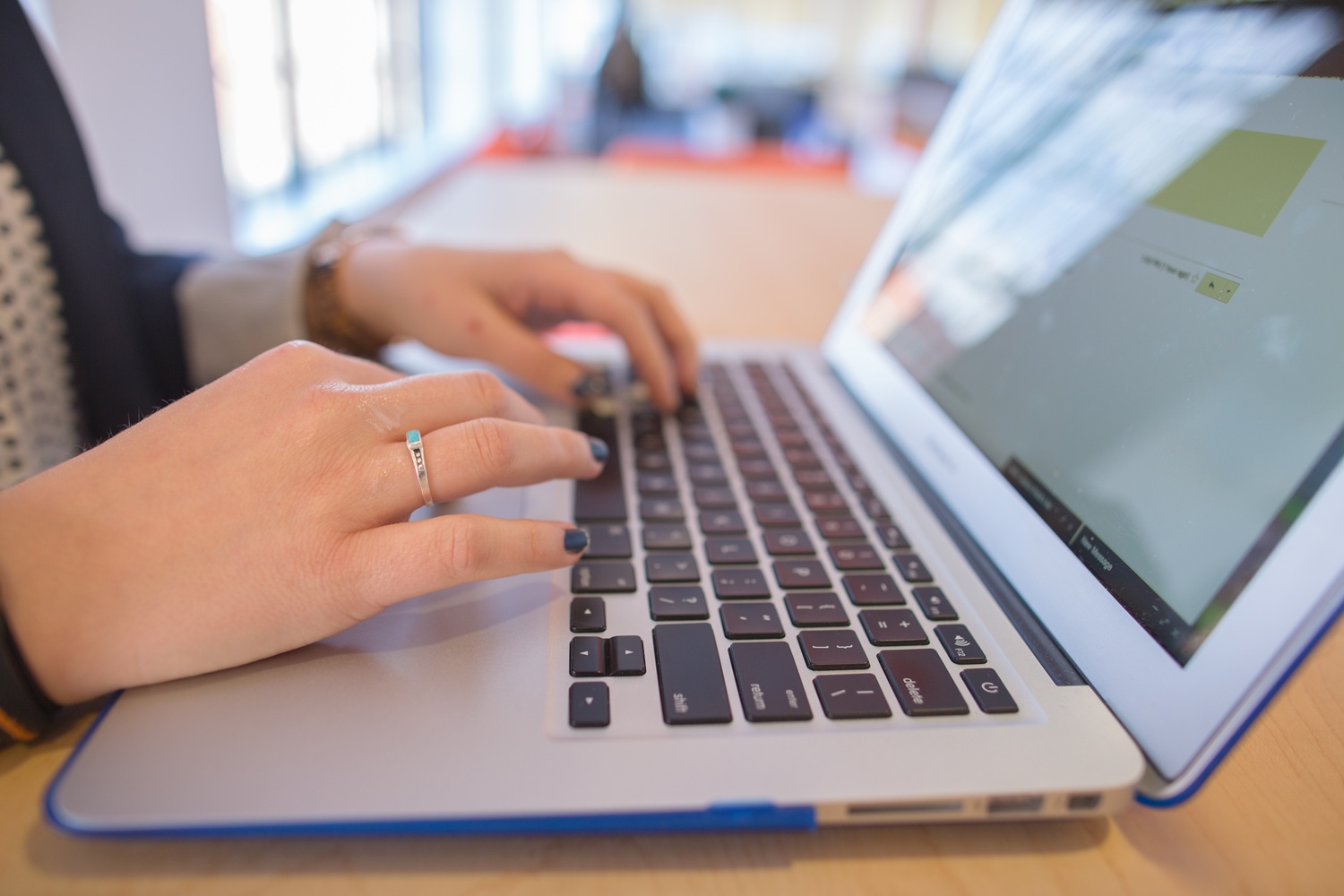 Woman typing on laptop computer.